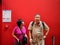 Senior Asian couple stands at red wall, Musee d`Orsay, Paris, France