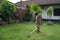 Senior asian man mowing grass at his own home garden