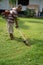 Senior asian man mowing grass at his own home garden