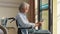 Senior asian man sitting in wheel chair using digital tablet