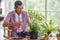 Senior Asian man watering for a small tree for a hobby in home planting corner with happiness and calm