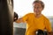 Senior asian sport man in  boxing gloves punching bag  in fitness gym . elder male exercising , workout, training ,healthy ,