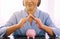 Senior asian woman hands cover above piggy bank for retirement,Saving money concept