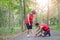 Senior asian woman with man or personal trainer tying shoe laces in the park