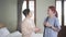 Senior Asian woman talking with Asian woman nurse wearing scrubs in the bedroom. Caregiver visit at home. Home health care.