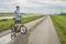 senior athletic man is riding a folding bike - biking on a levee trail along Chain of Rocks Canal