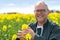 Senior attractive farmer working in a field of colza - Nature co