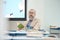 Senior Bearded Professor Sitting at Desk in Class