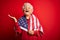 Senior beautiful grey-haired patriotic woman wearing united states flag over red background very happy and excited, winner