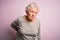 Senior beautiful woman wearing casual t-shirt standing over isolated pink background Suffering of backache, touching back with
