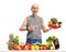 Senior behind a table with fruit and vegetables holding a plate