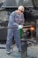 Senior blacksmith using gas torch