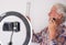 Senior blogger with recording video while shaving . White-haired and beard, white background