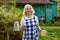 Senior blonde beautiful woman going with teapot to her guests at her farm