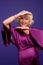 Senior blonde woman in an evening violet dress looking wonderful