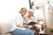 A senior blonde woman has a tablet in her hand while a young woman explains how to use the internet, social networks and online