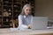 Senior businesslady sit at desk working using laptop