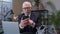 Senior businessman grandfather with smartphone texting checking email messages online at work