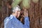 Senior businessman leaning on a tree trunk of a sequia