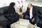 Senior Businessman Shaking hands with Woman wearing hijab