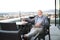 Senior businessman working on tablet in rooftop cafe