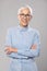 Senior businesswoman with glasses in a blue shirt and short white hair and glasses