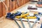 Senior carpenter glueing wooden craft surface and joining with clamps. Woodwork carpenter with equipment and tools at workshop.