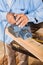 Senior Carpenter Shaving Wood With Electric Planer