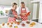 Senior caucasian couple smiling happy baking sweets using touchpad at the kitchen