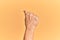 Senior caucasian hand over yellow isolated background doing protest and revolution gesture, fist expressing force and power