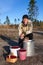 Senior Caucasian man after collecting red bilberry in the forest with full buckets, a basket