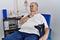 Senior caucasian man at physiotherapy clinic holding crutches touching painful neck, sore throat for flu, clod and infection