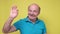 Senior caucasian man showing small size sign with fingers looking and the camera.