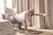 Senior caucasian men practices yoga asana chakravakasana, bird pose at home