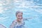 Senior caucasian smiling woman with gray hair enjoying in outdoor thermal swimming pool.