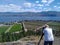 A senior Caucasian white man taking photograph of the landscape overlooking the vineyards and farmland in Okanagan Lake, West