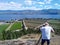 A senior Caucasian white man taking photograph of the landscape overlooking the vineyards and farmland in Okanagan Lake, West