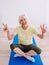 Senior cheerful peaceful woman doing yoga indoor.