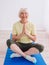 Senior cheerful peaceful woman doing yoga indoor.