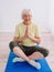 Senior cheerful peaceful woman doing yoga indoor.