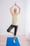 Senior cheerful peaceful woman doing yoga indoor.