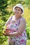 Senior cheerful woman at work in own garden at summer