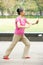 Senior Chinese Woman Doing Tai Chi In Park