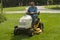 Senior Citizen Cutting Grass On A Riding Lawnmower