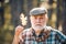 Senior citizen stroll in a park in autumn. Portrait of a senior man outdoors walking in a park. Portrait of a senior man