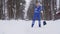 Senior cleaner removing snow with broom.