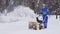 Senior cleaner using snow removal machine.