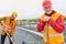 Senior construction worker and a colleague shovel concrete