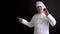 Senior cook man, wearing chef hat raising finger, black background