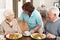 Senior Couple Being Served Meal By Carer